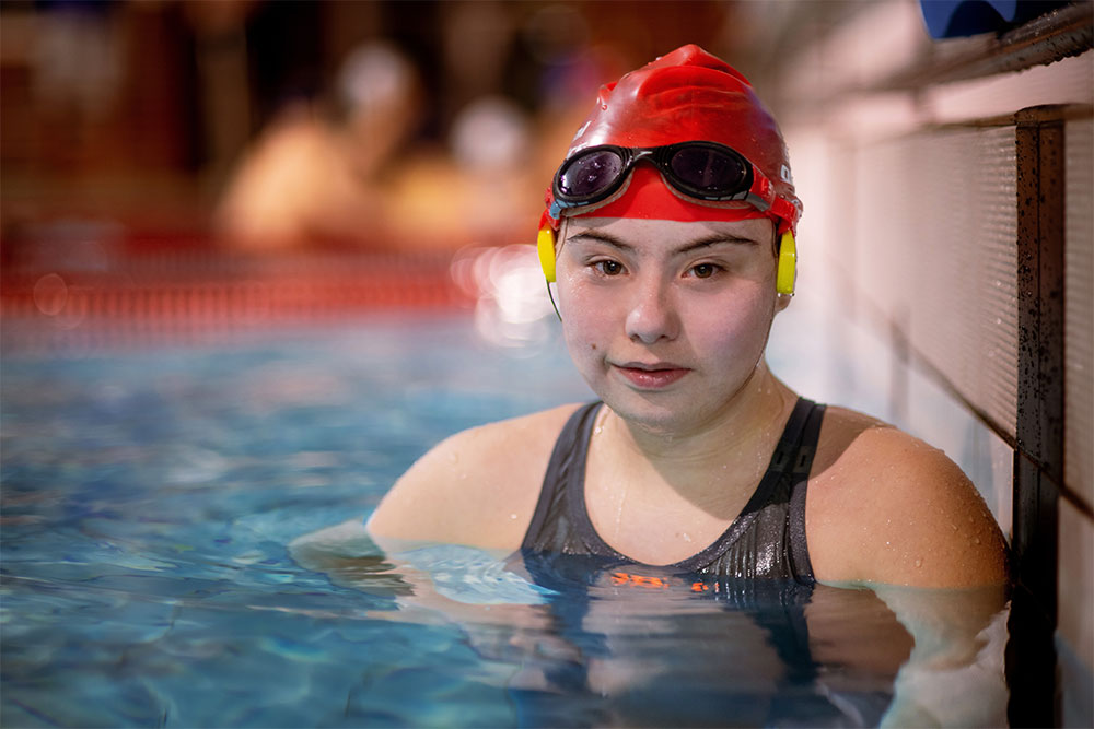 female swimmer wearing swim gear by poolside 